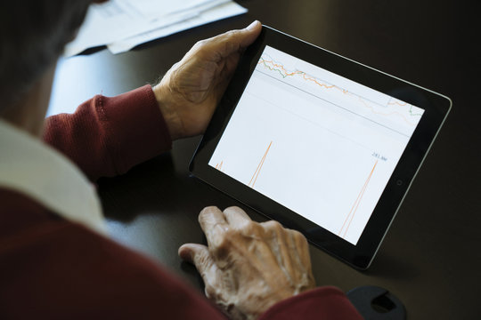 Close-up of financial adviser analyzing data on digital tablet