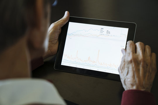 Close-up of financial adviser analyzing data on digital tablet