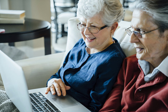 Senior couple using laptop computer in living room