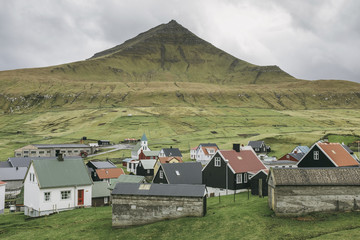 High angle view of village against mountain and cloudy sky