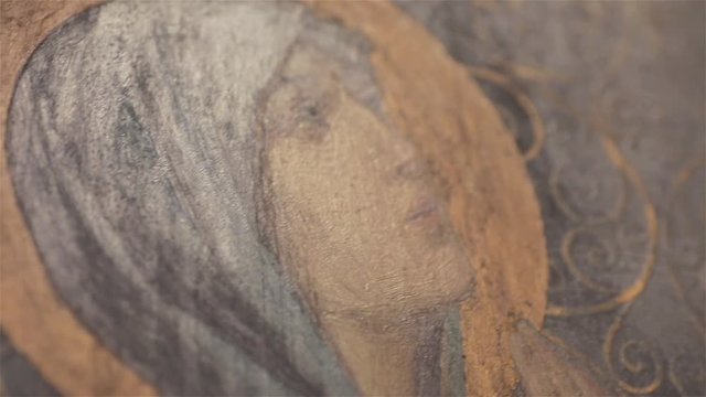 NICE, FRANCE - JULY 27, 2017: Angled detail of icon image of Virgin Mary in St Nicholas Orthodox Cathedral macro close up light moving. Oil painting of Mother of God look with signs of brush marks