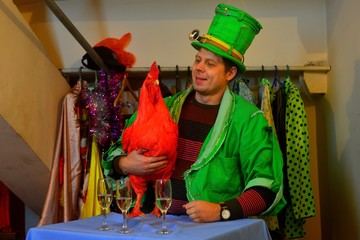 Photo indoor of Circus artist in bright clothes with a cock