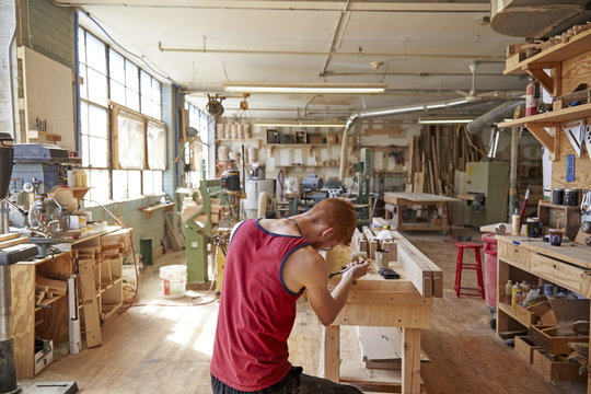 Rear view of carpenter working in workshop