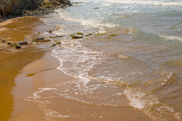 small waves break intro yellow beach