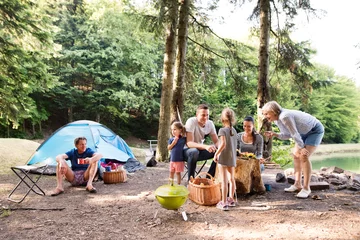 Foto op Plexiglas Mooie familie kamperen in het bos, samen eten. © Halfpoint