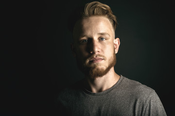 portrait of young man above black background