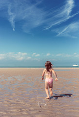Fototapeta na wymiar enfant jouant sur la plage