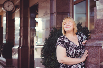 Young stylish woman walking on the city street at autumn. Casual fashion, elegant look. Plus size model. Happy overweight woman walking the city streets