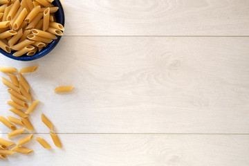 Pasta in blue bowl on white table
