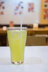 Iced Green tea with a straw on table