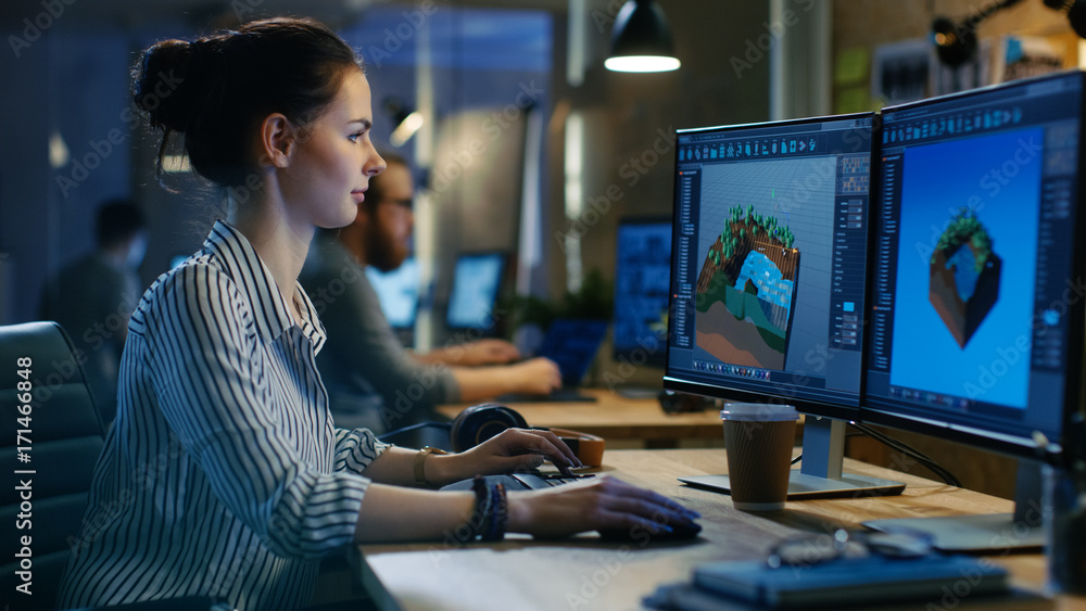 Aufkleber Female Game Developer Works on a Level Design on Her Personal Computer with Two Displays. She works in a Creative Office Space.