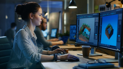 Female Game Developer Works on a Level Design on Her Personal Computer with Two Displays. She works...