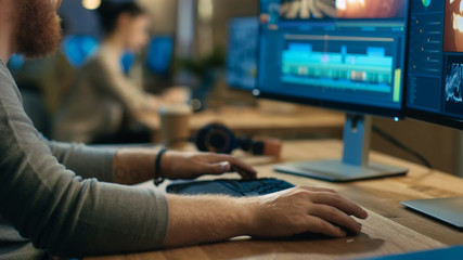 Male Videographer Edits and Cuts Footage and Sound on His Personal Computer with Two Displays. His Office is Modern and Creative Loft Studio.