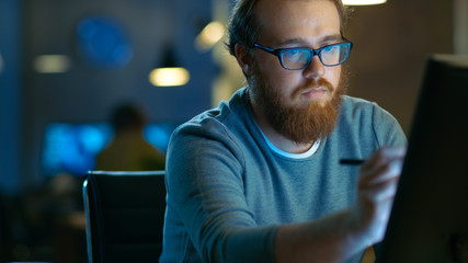 Talented Young Concept Artist Drawing on a Digital Pen Display Tablet While Sitting at His Working...