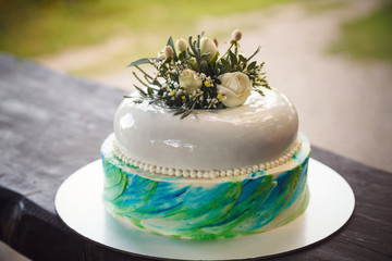 Birthday cake decorated by flowers on wood background