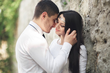 Gorgeous newlywed posing near beautiful wall of plants bushes trees in their wedding day