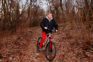 Naklejka premium Cyclist Riding the Bike on a Trail in Summer Forest