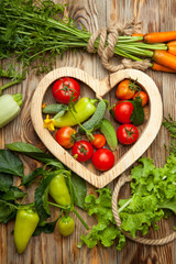 Set of different fresh raw colorful vegetables near the wooden tray, light background