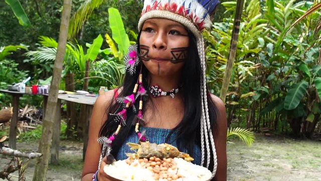 Native Brazilian Woman eating a traditional brazilian food