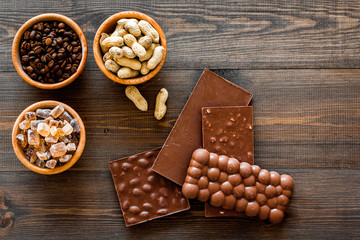 Chocolate with nuts on dark wooden background top view copyspace