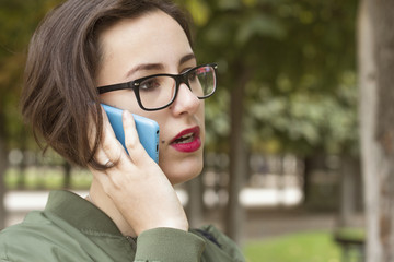 Fashion portrait of young beautiful woman talking on cell phone.