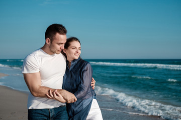 Beautiful young couple on the sandy beach of the sea