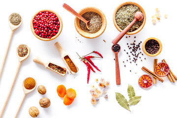 Spicy food cooking with spices and dry herbs white kitchen desk background top view pattern