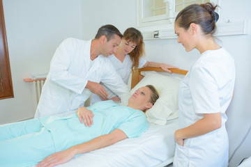 woman and doctors with at hospital ward