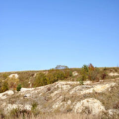 Fototapeta na wymiar Autumn landscape with trees, bushes and limestone boulders