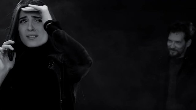 Man attacking and kidnapping woman at night black and white dolly shot