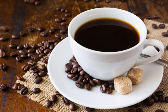 Coffee cup with coffee beans and sack background