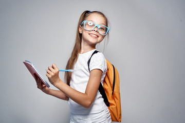 girl with glasses holds a notepad