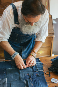Closeup of Cool Senior Tailor Using Fixing Pins on Boro Denim Patchwork