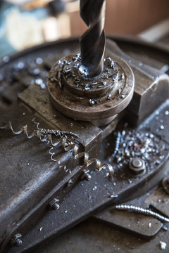 Drill close up - Close up drill tool in chuck during metal cutting process hole boring in iron piece at industrial factory workshop