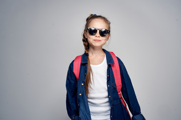 girl in sunglasses on gray background, smile