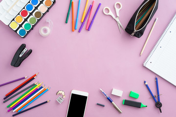 Colourful school supplies with a smartphone with copyspace in the center