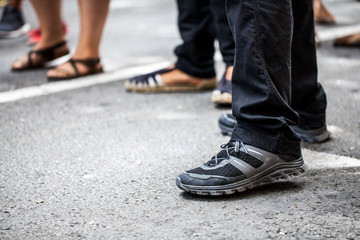 Man with sport shoes waiting in a queue in street