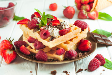 Belgian waffles with raspberry, strawberry, whipped cream and grated chocolate