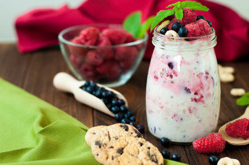 Jar with blueberry raspberry overnight oat on the rustic wooden background