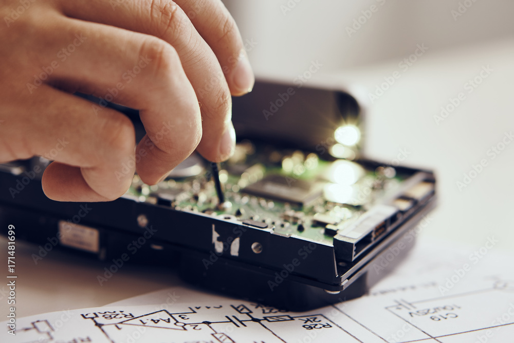Poster man fixing a computer, close-up, microcircuits