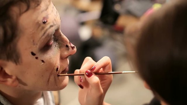 Makeup artist at work applying halloween makeup