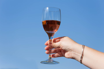 A glass of wine is a toast against the blue sky