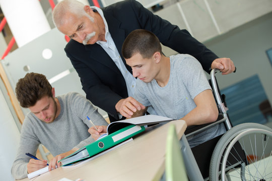 student in wheelchair working in assitance class