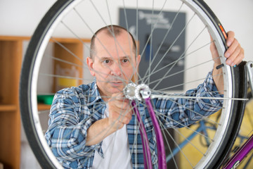 man fixing bicycle rim wheels manufacturing