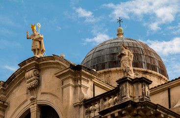 A photo of the roof and golden statues of the St Blaise Church in the Old Town / City of Dubrovnik in Croatia - obrazy, fototapety, plakaty