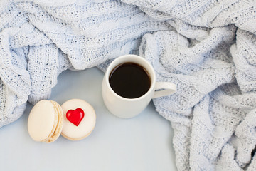 Cup of coffee and the macaroons on the soft plaid
