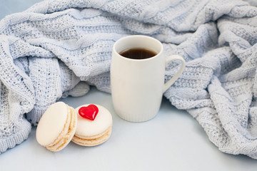 Cup of coffee and macaroons on the soft plaid