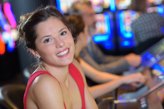 smiling young woman ready to play at slot machine