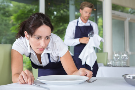 waitress setting the table in a restaurant