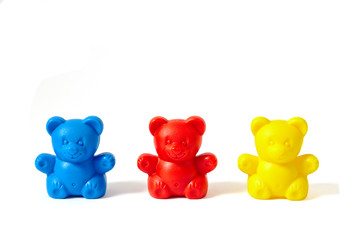 Blue, red and yellow plastic toy bears isolated on white background